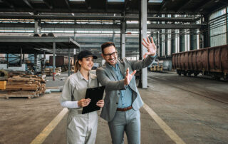 Business owner on shop floor with employee - workers' compensation insurance