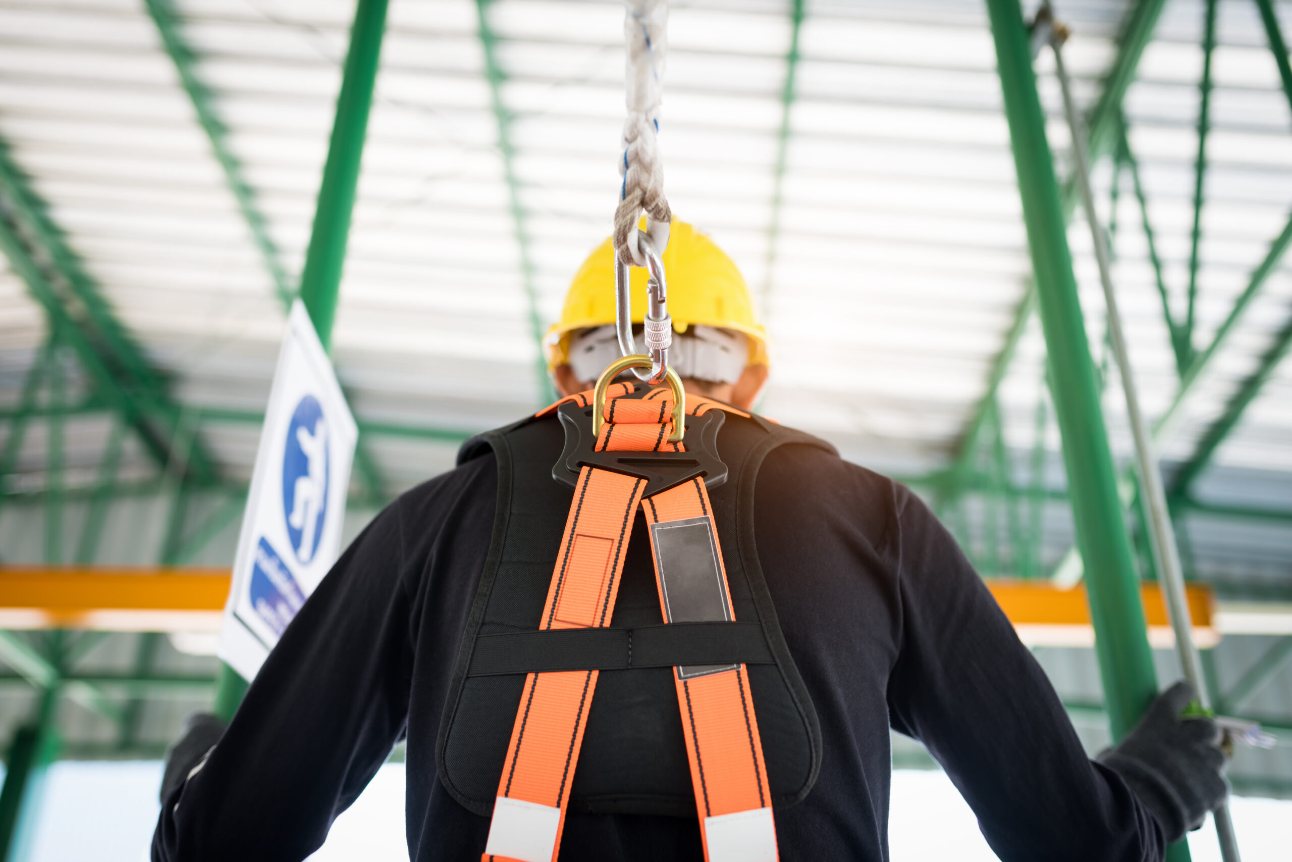 Construction worker wearing safety harness and safety line working at high place